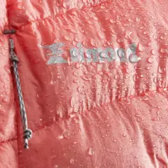 Zbity puch w różowej kurtce, pokrytej kroplami wody. Widoczny zamek i logo marki.
