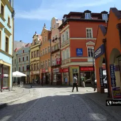 Kolorowe kamienice i brukowana ulica tworzą urokliwy zakątek, idealny do odkrywania **Jelenia Góra atrakcje**.