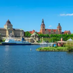 Widok na Odrę i zabytkowe budynki, w tym Muzeum Narodowe, to jedne z głównych atrakcji Szczecina. Statek "Navigator XXI" zacumowany przy nabrzeżu.