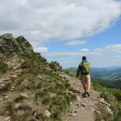 Wędrowiec z plecakiem na skalistym szlaku. Piękne Bieszczady atrakcje czekają na odkrycie.