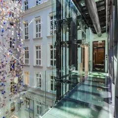 Nowoczesny dziedziniec hotelowy z instalacją szklanych kul i przeszklonymi korytarzami. Idealne miejsce na city break w Polsce.
