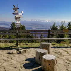 Słup z drogowskazami turystycznymi w pobliżu parkingu na Turbaczu. W tle piękne widoki na Tatry.