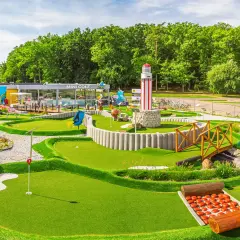 Mini golf w Rewalu to świetna zabawa! Wesołe dekoracje, w tym latarnia morska i rekin, zachęcają do gry.