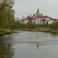 Malowniczy widok na rzekę i klasztor w Supraślu. Wiosna budzi do życia przyrodę, a zabytkowa architektura zaprasza do odkrywania supraśl atrakcje.