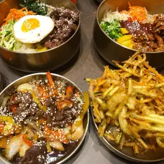 Pyszne dania kuchni koreańskiej, idealne dla polecanych restauracji w Poznaniu: bibimbap, bulgogi i chrupiące warzywa w cieście.