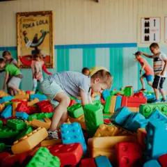 Dzieci bawią się w kolorowym basenie z klocków w parku rozrywki dla małych dzieci.