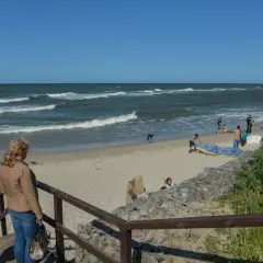 Rodzina na plaży, fale na morzu. Jastrzębia Góra atrakcje to piękne widoki i wypoczynek nad Bałtykiem.