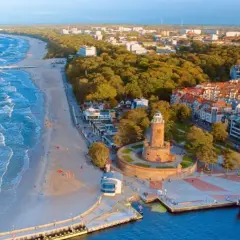 Malownicze miejscowości nad morzem z latarnią morską, plażą i portem.
