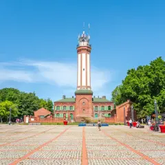 Latarnia morska w Niechorzu i plac z atrakcjami turystycznymi.
