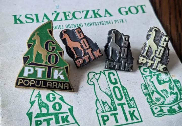 Książeczka GOT z odznakami turystycznymi PTTK. Odznaki przedstawiają kozice i napis GOT PTTK.