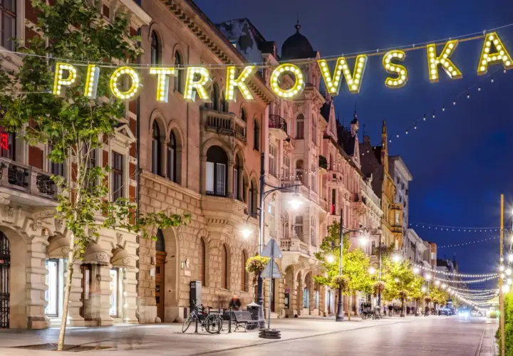 Ulica Piotrkowska nocą, pełna świateł i architektonicznych atrakcji Łodzi.