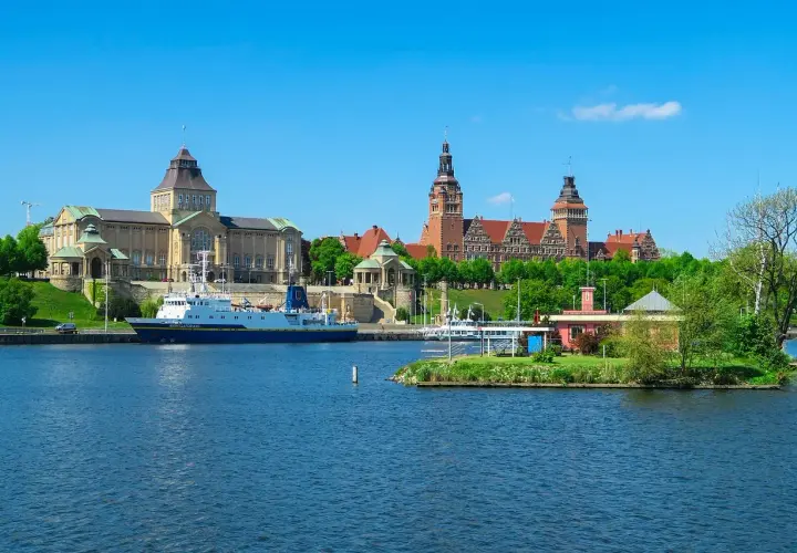 Widok na Odrę i zabytkowe budynki, w tym Muzeum Narodowe, to jedne z głównych atrakcji Szczecina. Statek "Navigator XXI" zacumowany przy nabrzeżu.