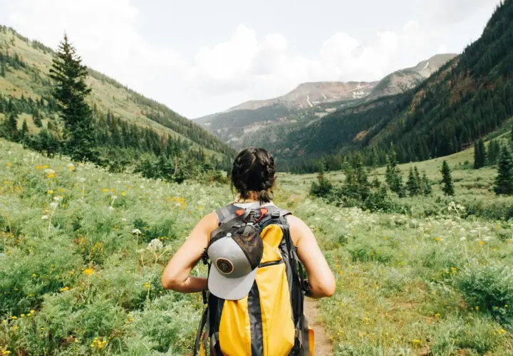 Kobieta z plecakiem wyrusza na szlak. To idealne miejsce na trekking, gdzie każdy krok to przygoda, a nie tylko zwykły hiking.