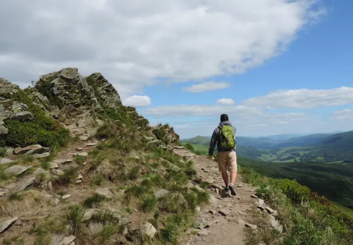 Wędrowiec z plecakiem na skalistym szlaku. Piękne Bieszczady atrakcje czekają na odkrycie.