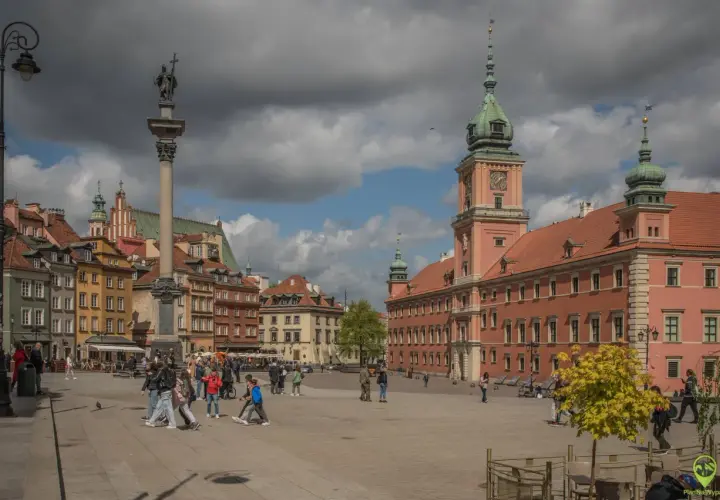 Kolumna Zygmunta i Zamek Królewski na placu w Warszawie. Wiele osób spaceruje, odkrywając warszawskie atrakcje.