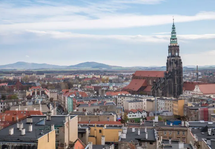 Widok na Świdnicę z dominującą wieżą katedry. Miasto oferuje wiele atrakcji, w tym zabytkową architekturę i malownicze krajobrazy.