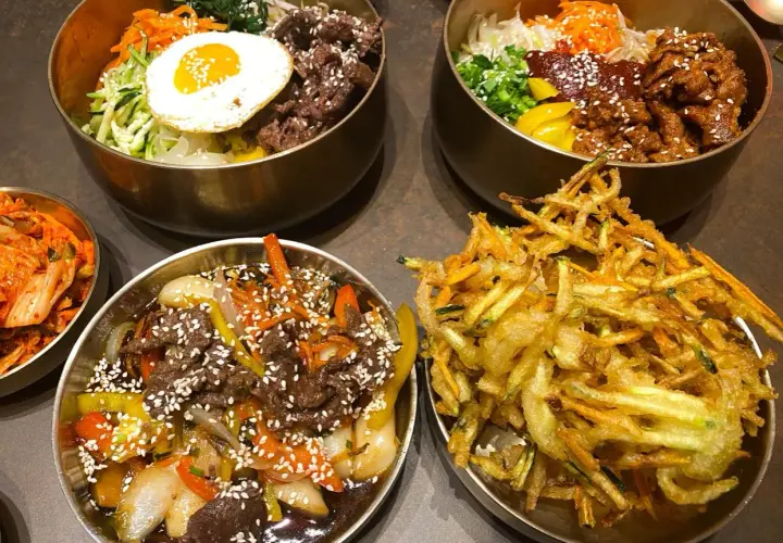 Pyszne dania kuchni koreańskiej, idealne dla polecanych restauracji w Poznaniu: bibimbap, bulgogi i chrupiące warzywa w cieście.