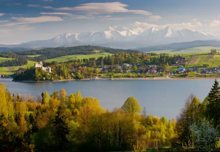 Zamek w Niedzicy nad Jeziorem Czorsztyńskim, otoczony zielenią i górami. Pieniny atrakcje w pełnej krasie.