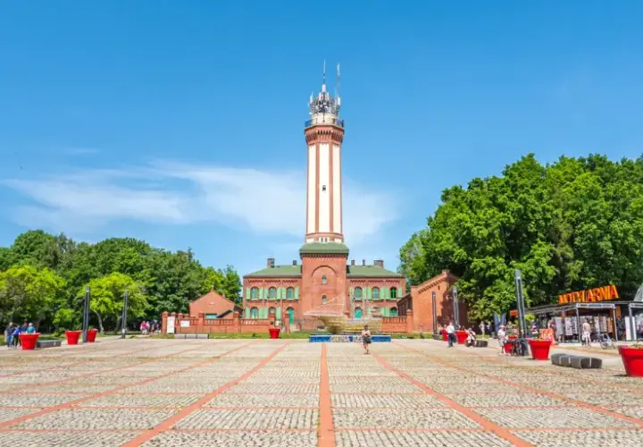 Latarnia morska w Niechorzu i plac z atrakcjami turystycznymi.