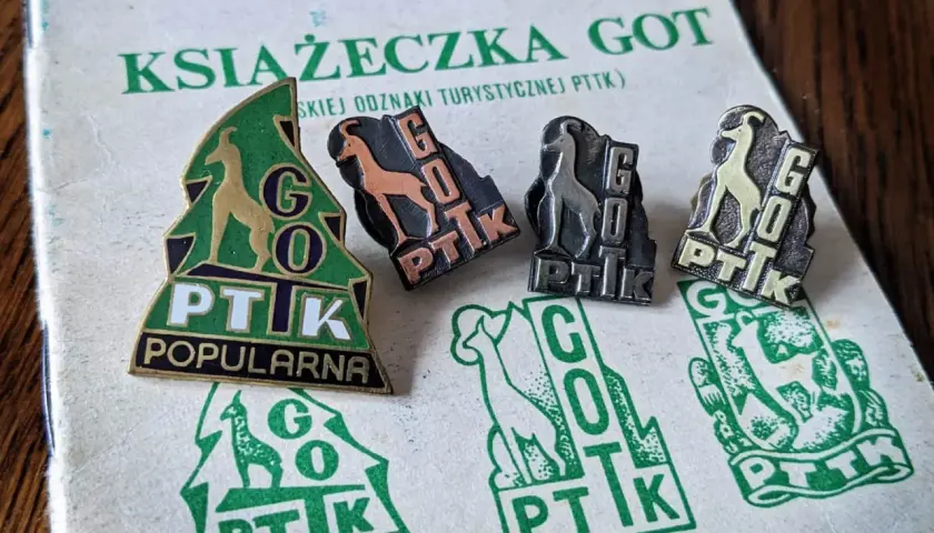 Książeczka GOT z odznakami turystycznymi PTTK. Odznaki przedstawiają kozice i napis GOT PTTK.