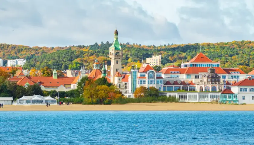 Sopot atrakcje: malowniczy widok na plażę, morze i zabytkowe budynki z wieżą widokową w jesiennej scenerii.