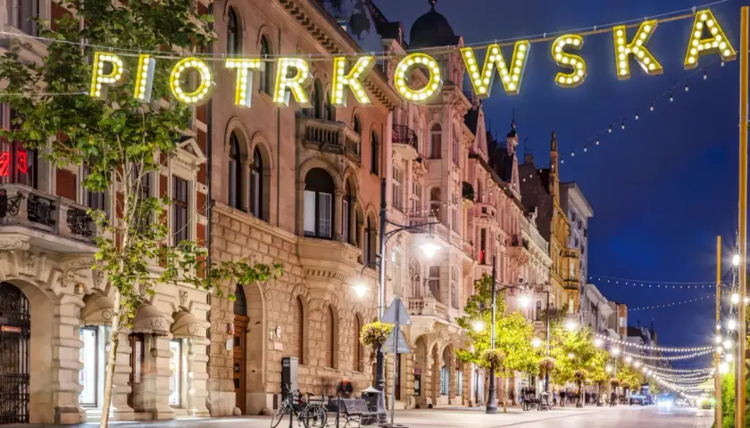Ulica Piotrkowska nocą, pełna świateł i architektonicznych atrakcji Łodzi.