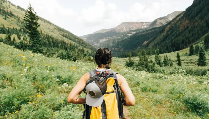 Kobieta z plecakiem wyrusza na szlak. To idealne miejsce na trekking, gdzie każdy krok to przygoda, a nie tylko zwykły hiking.