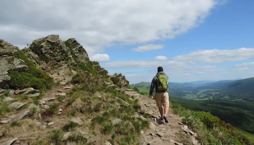 Wędrowiec z plecakiem na skalistym szlaku. Piękne Bieszczady atrakcje czekają na odkrycie.
