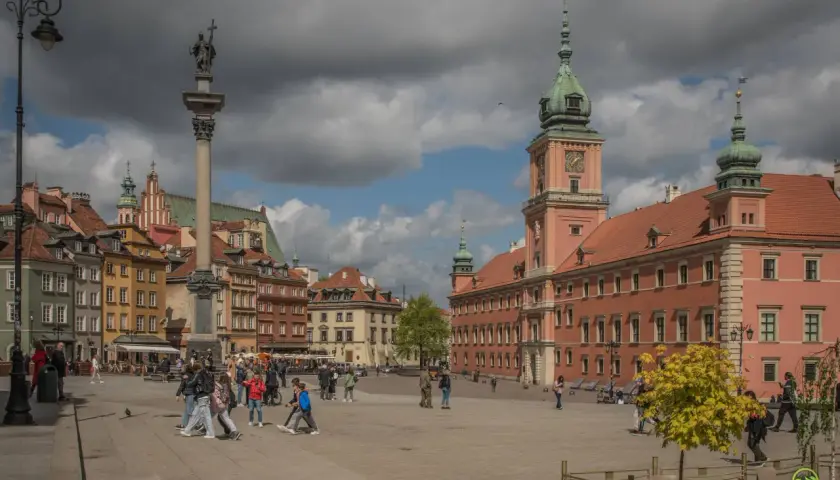 Kolumna Zygmunta i Zamek Królewski na placu w Warszawie. Wiele osób spaceruje, odkrywając warszawskie atrakcje.