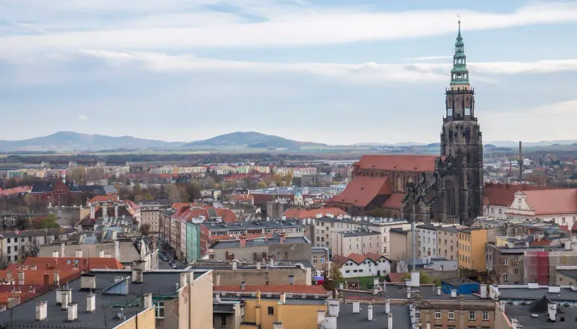Widok na Świdnicę z dominującą wieżą katedry. Miasto oferuje wiele atrakcji, w tym zabytkową architekturę i malownicze krajobrazy.