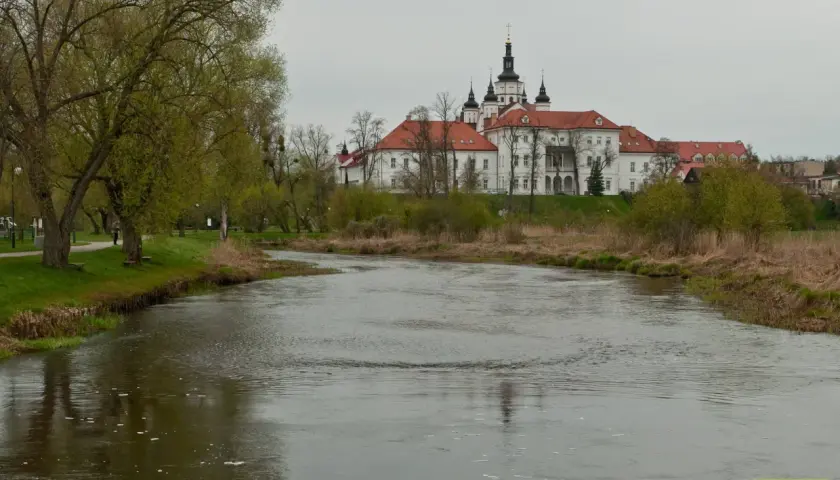 Malowniczy widok na rzekę i klasztor w Supraślu. Wiosna budzi do życia przyrodę, a zabytkowa architektura zaprasza do odkrywania supraśl atrakcje.