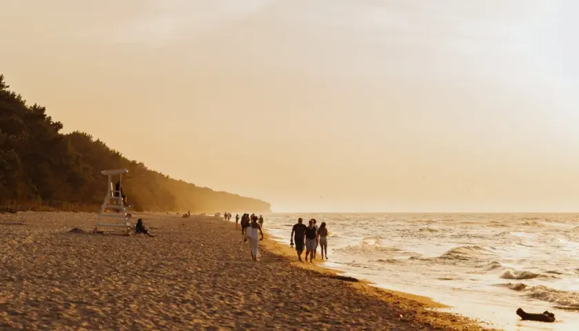 Spacerem po plaży w Pobierowie, podziwiając zachód słońca. To jedna z głównych atrakcji tego miejsca.