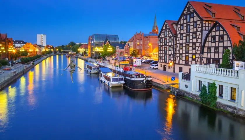 Bydgoszcz atrakcje: rzeka Brda, statki, zabytkowa zabudowa i słynny siłaczek na linie. Wieczorny klimat miasta.