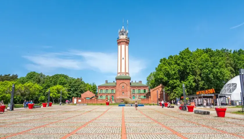 Latarnia morska w Niechorzu i plac z atrakcjami turystycznymi.