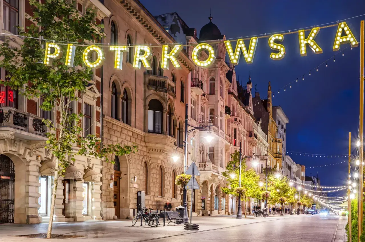 Ulica Piotrkowska nocą, pełna świateł i architektonicznych atrakcji Łodzi.
