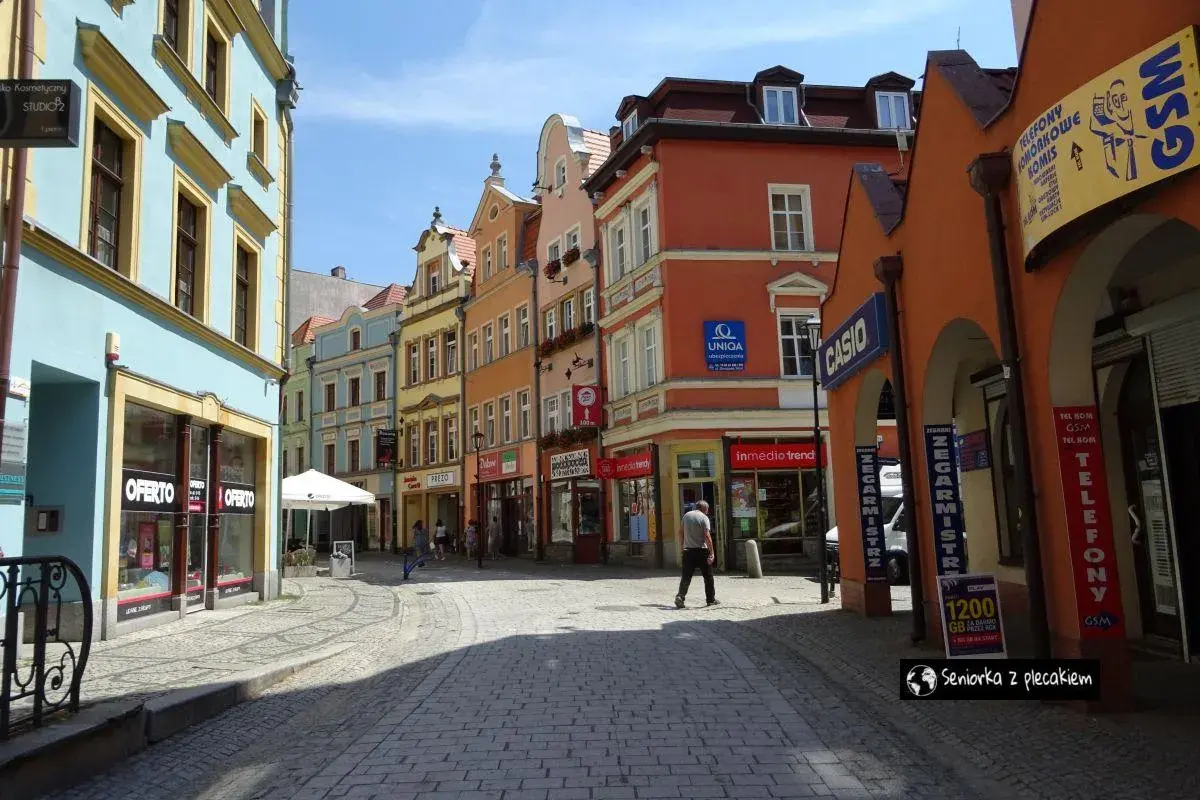 Kolorowe kamienice i brukowana ulica tworzą urokliwy zakątek, idealny do odkrywania **Jelenia Góra atrakcje**.