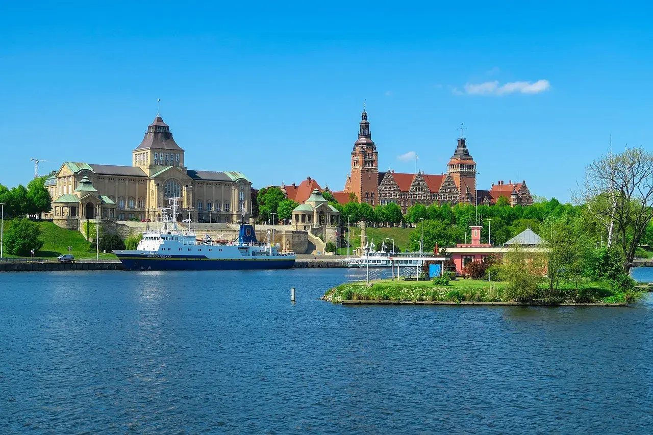 Widok na Odrę i zabytkowe budynki, w tym Muzeum Narodowe, to jedne z głównych atrakcji Szczecina. Statek "Navigator XXI" zacumowany przy nabrzeżu.