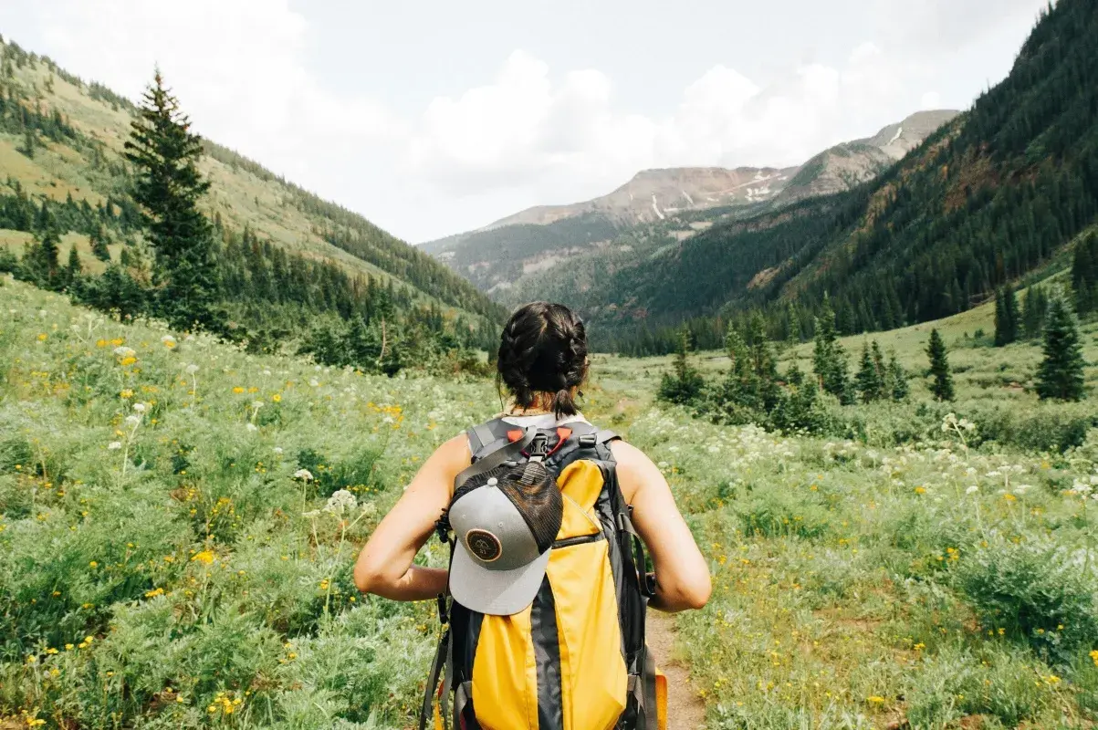 Kobieta z plecakiem wyrusza na szlak. To idealne miejsce na trekking, gdzie każdy krok to przygoda, a nie tylko zwykły hiking.
