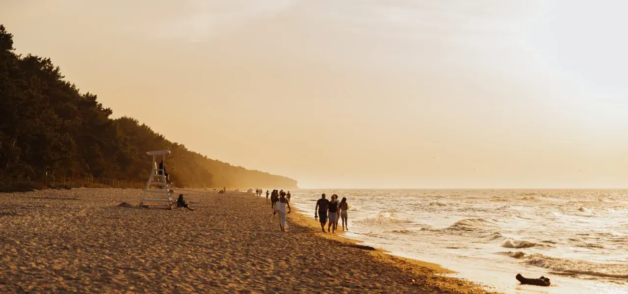 Spacerem po plaży w Pobierowie, podziwiając zachód słońca. To jedna z głównych atrakcji tego miejsca.
