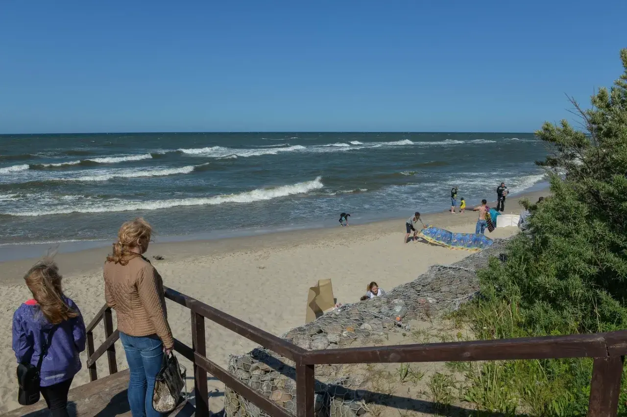 Rodzina na plaży, fale na morzu. Jastrzębia Góra atrakcje to piękne widoki i wypoczynek nad Bałtykiem.