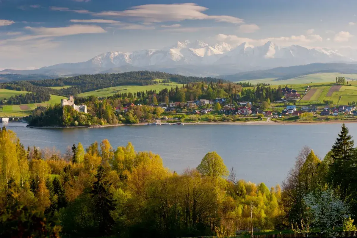 Zamek w Niedzicy nad Jeziorem Czorsztyńskim, otoczony zielenią i górami. Pieniny atrakcje w pełnej krasie.
