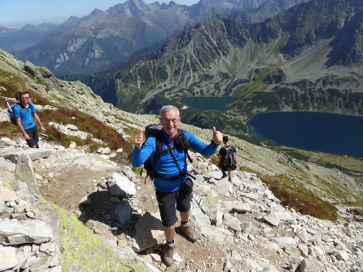 Wspaniały widok na Tatry z Kozi Wierch. Czas przejścia minął, a turyści cieszą się pięknem gór.