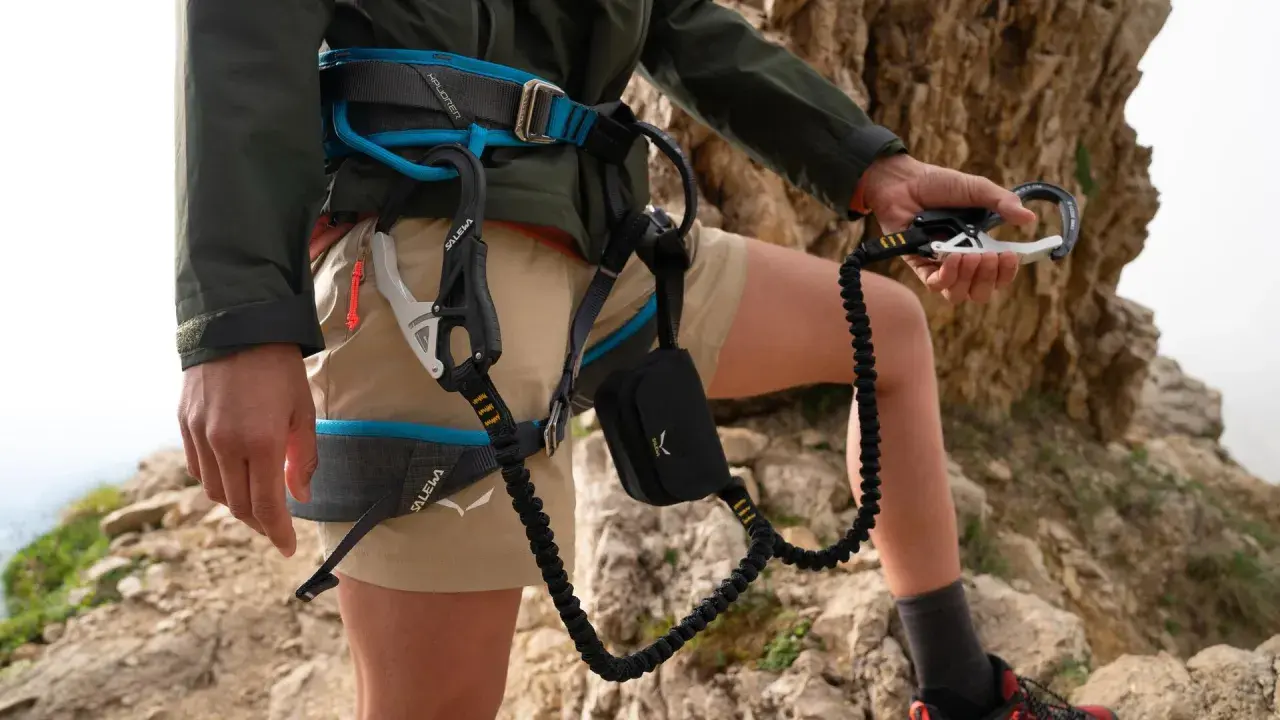 Wspinacz w uprzęży Salewa, gotowy do akcji. Salewa co to za firma? To marka sprzętu outdoorowego, która zapewnia bezpieczeństwo w górach.