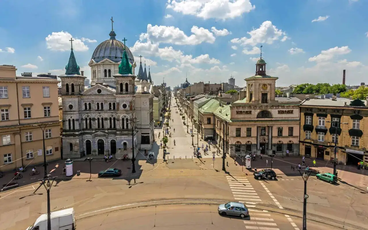 Widok na ulicę Piotrkowską w Łodzi. Wspaniałe łódzkie atrakcje, zabytkowe kamienice i kościół tworzą malowniczy krajobraz.