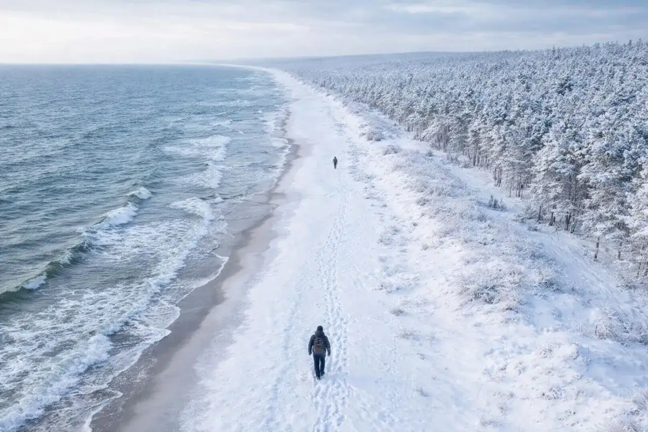 Spacer po zaśnieżonej plaży. Niska temperatura wody zachęca do morsowania, ale dziś tylko spacer.