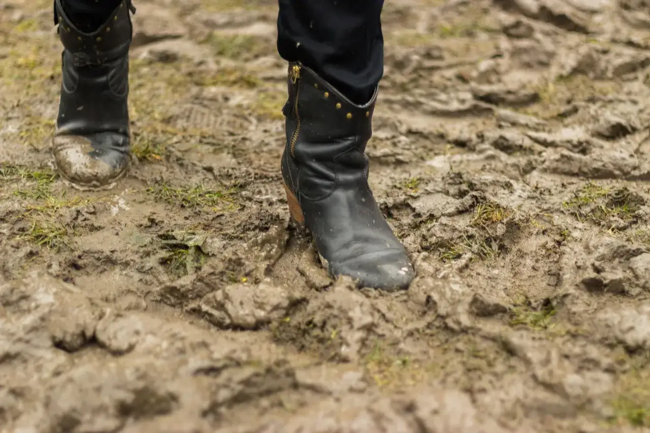 Czarne, błotniste buty po spacerze po błocie. Czas dowiedzieć się, jak wyprac buty, by znów lśniły.