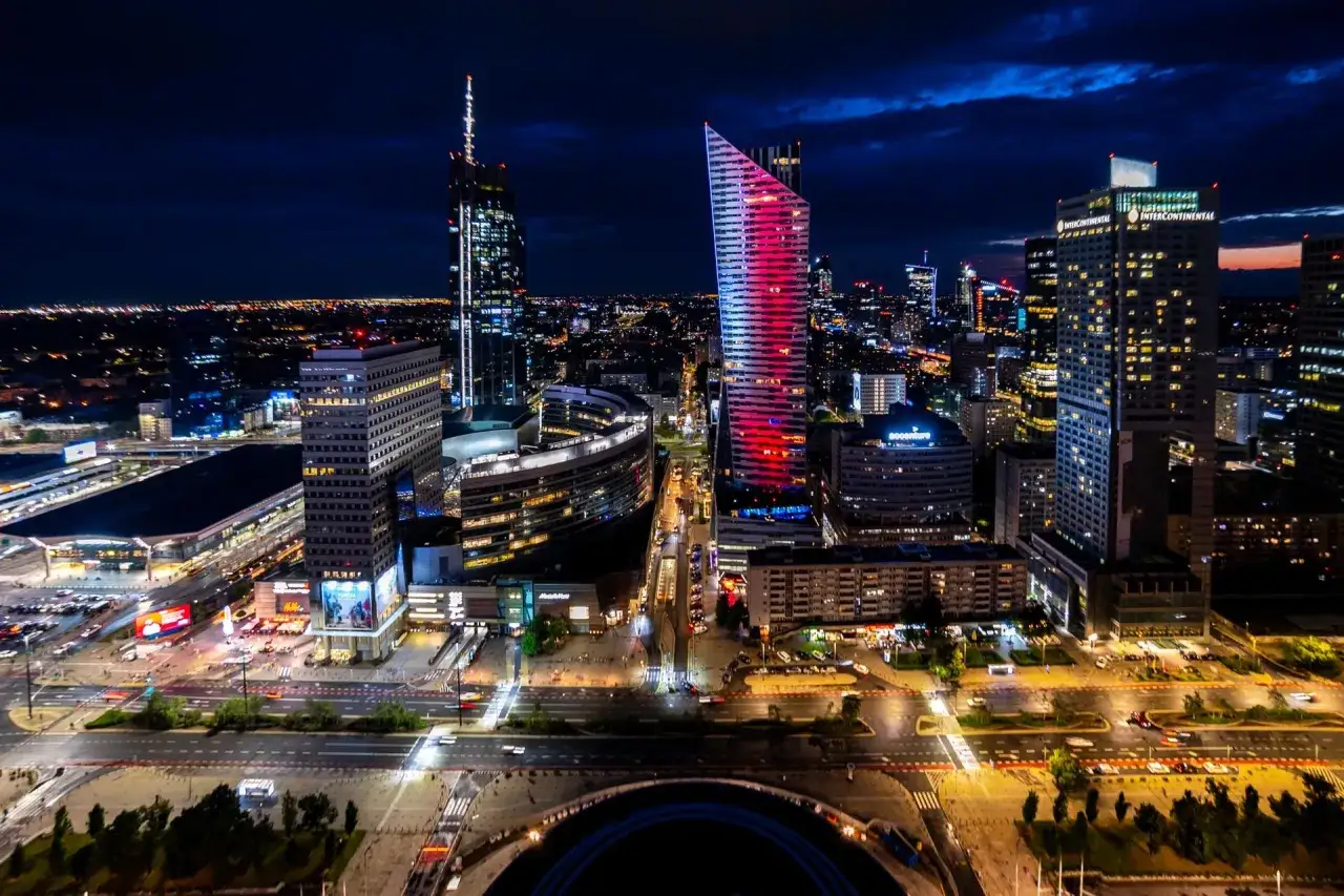 Warszawa nocą: lśniące wieżowce, ruch uliczny i światła miasta. Idealne miejsce na wieczorne atrakcje dla dorosłych.
