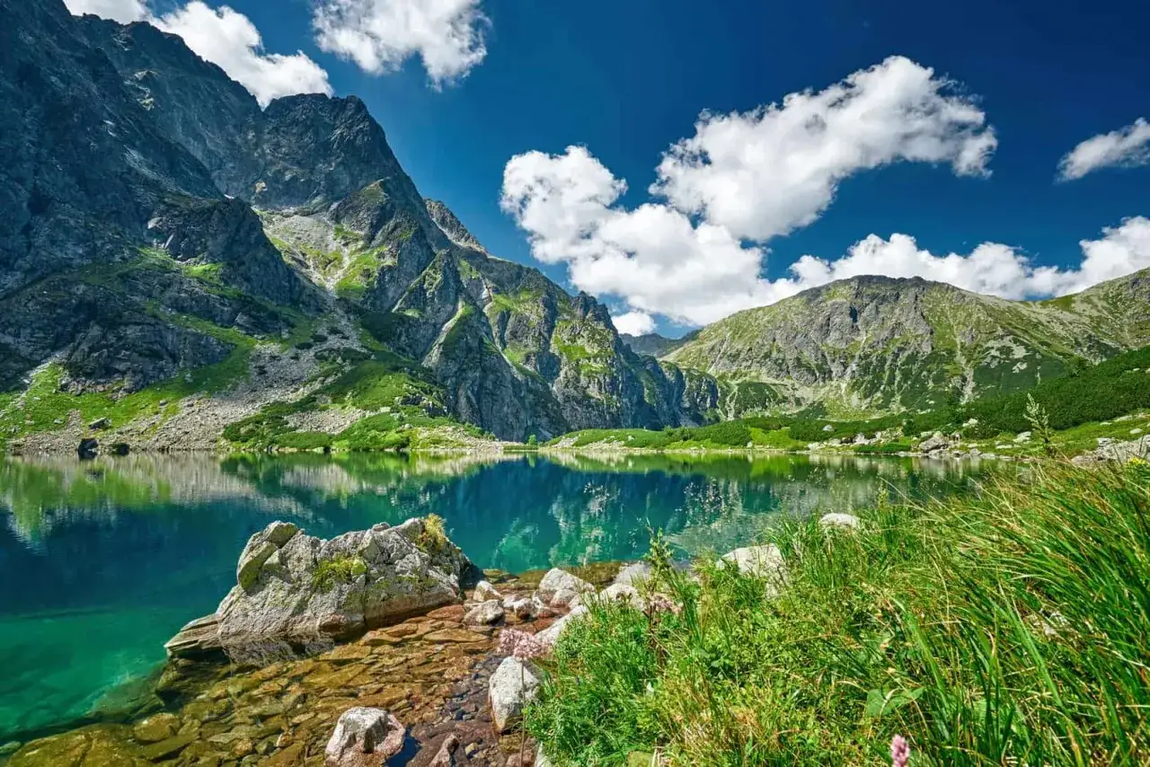 Piękne Tatry, idealne tatry szlaki dla średnio zaawansowanych. Jezioro Morskie Oko odbija skaliste szczyty i błękitne niebo.