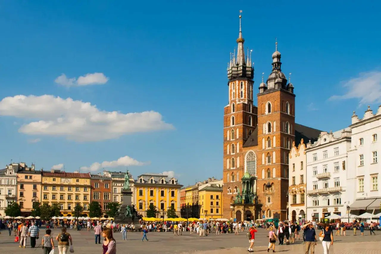 Rynek Główny w Krakowie, z Bazyliką Mariacką i Sukiennicami, tętni życiem. To serce miasta i jedne z najpiękniejszych atrakcji Krakowa.
