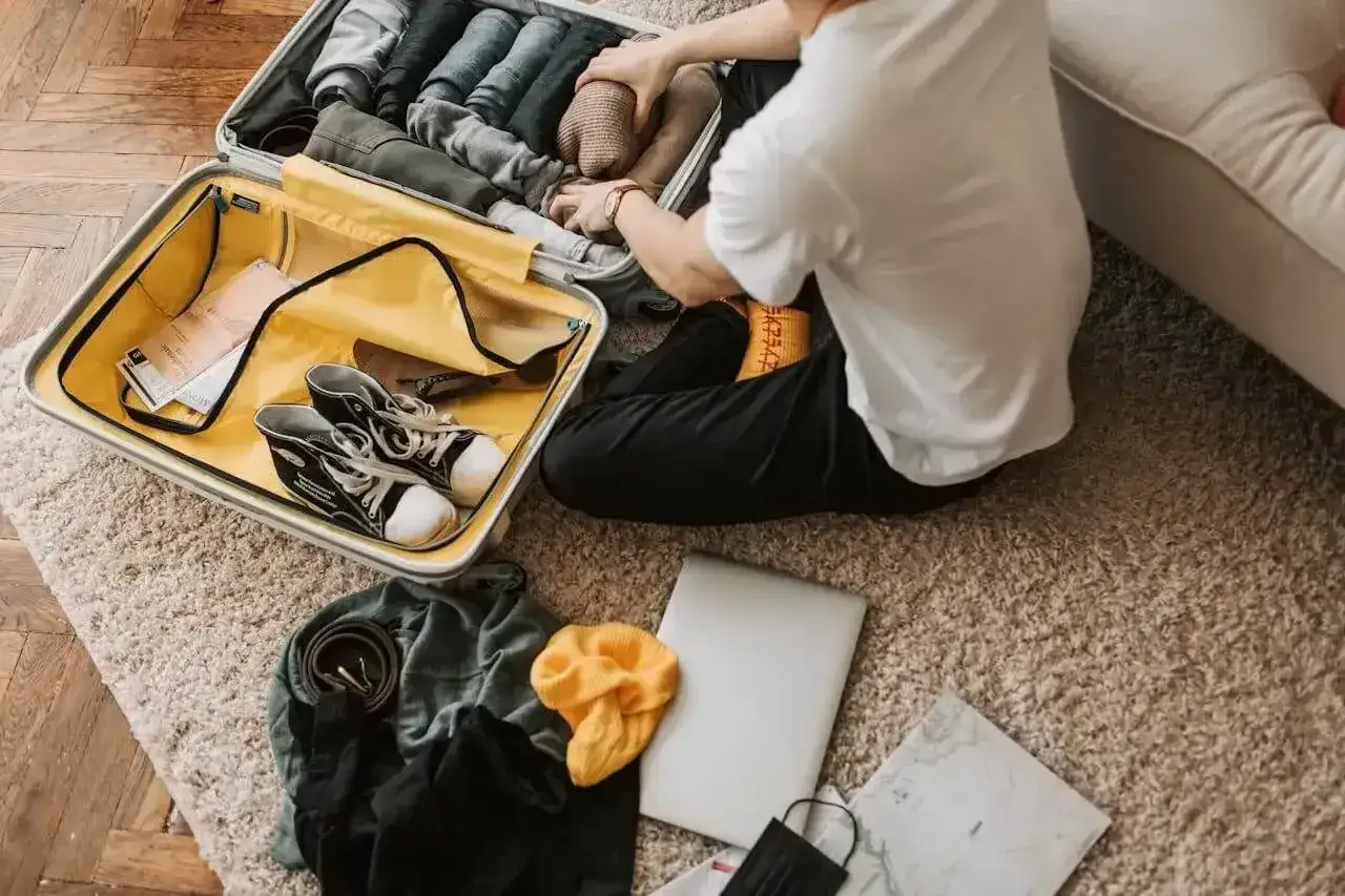 Pakowanie walizki: ubrania nad morze, buty, laptop i maseczka. Gotowy na wakacje!